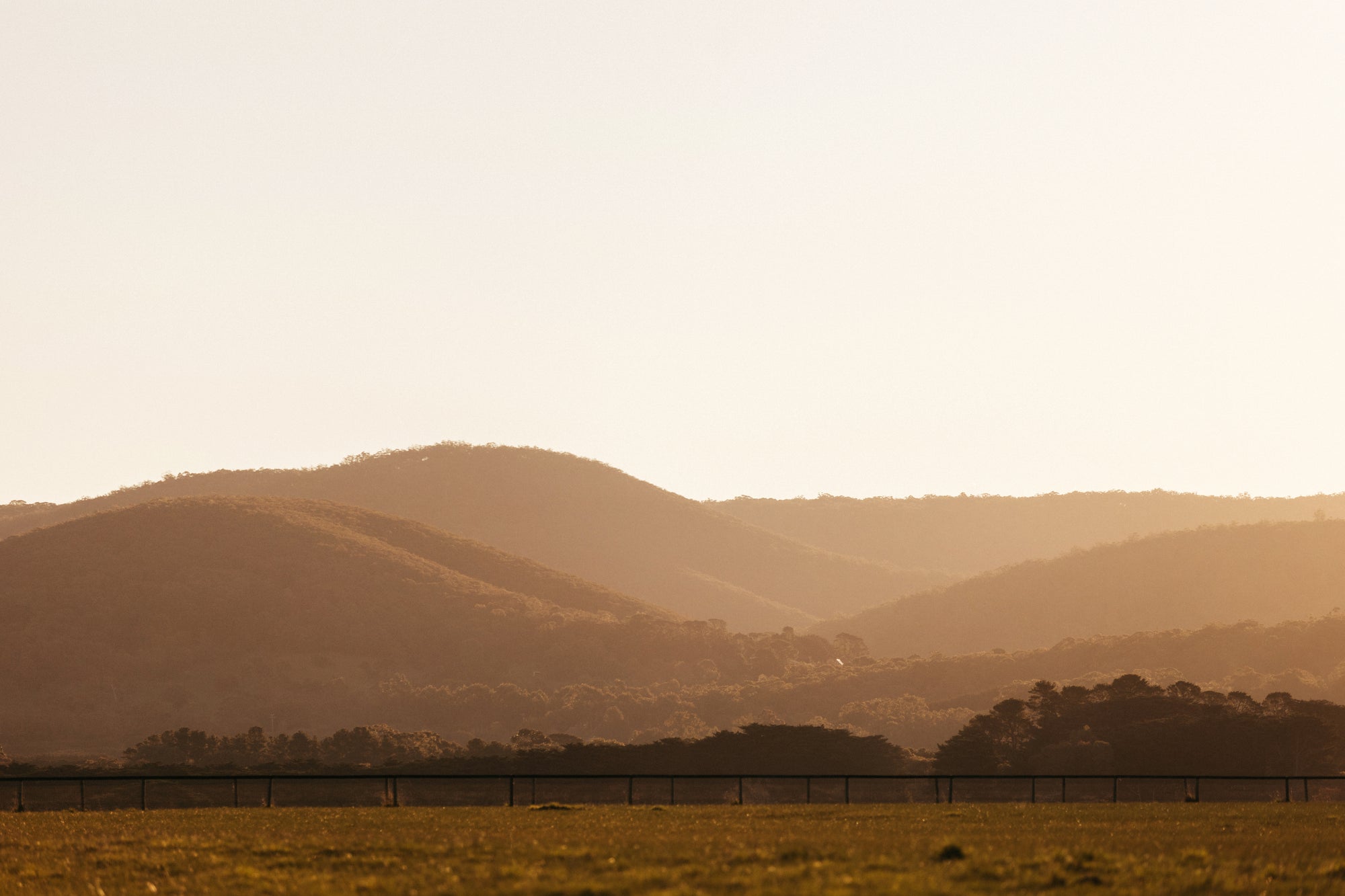 Sunset over the Macedon Ranges near Deep Creek, showing natural volcanic hills and native forest.