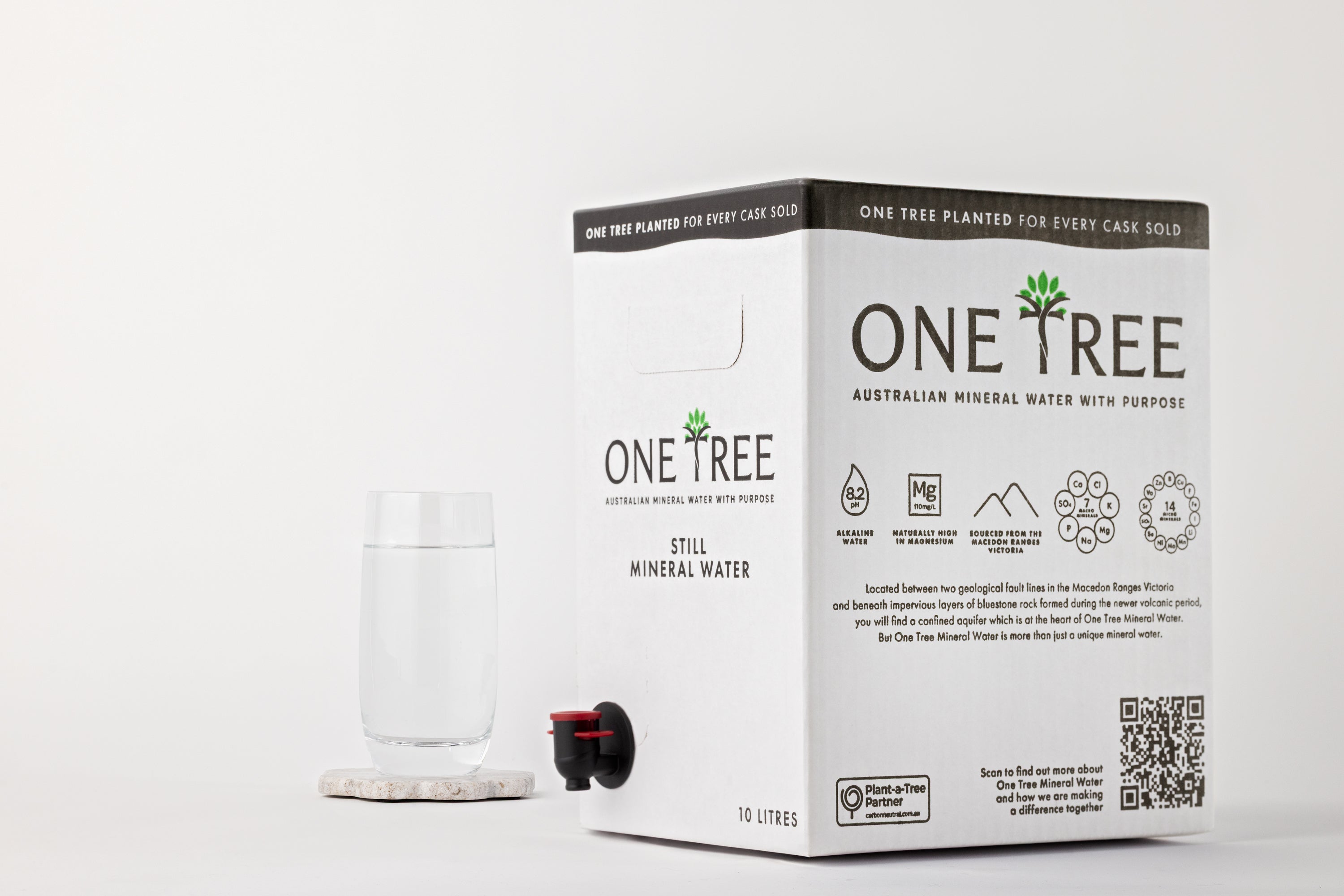 One Tree Still Mineral Water 10L cask with a glass of mineral water on stone coaster.